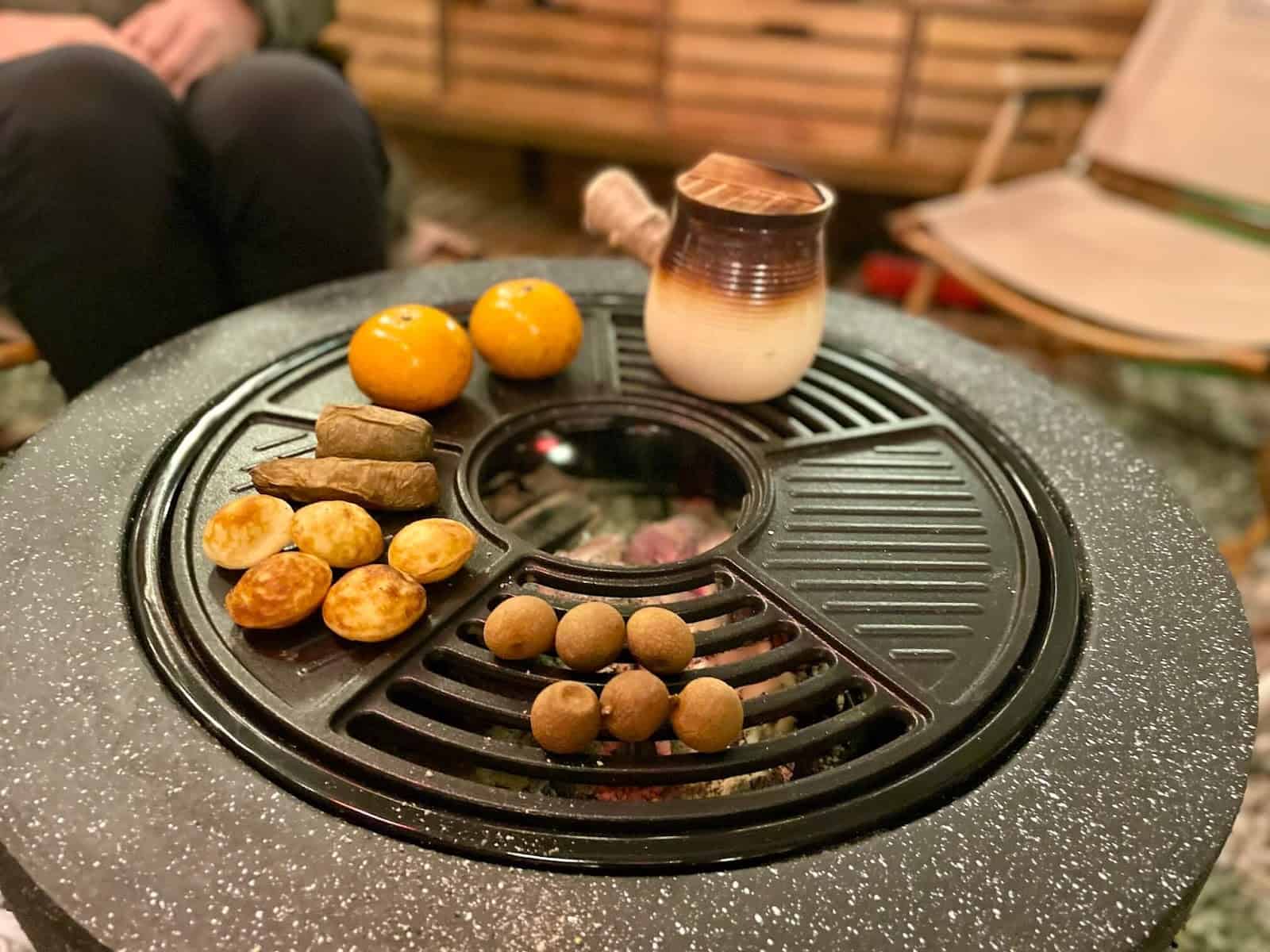 圍爐煮茶，將茶壺與茶點放在爐火上烤