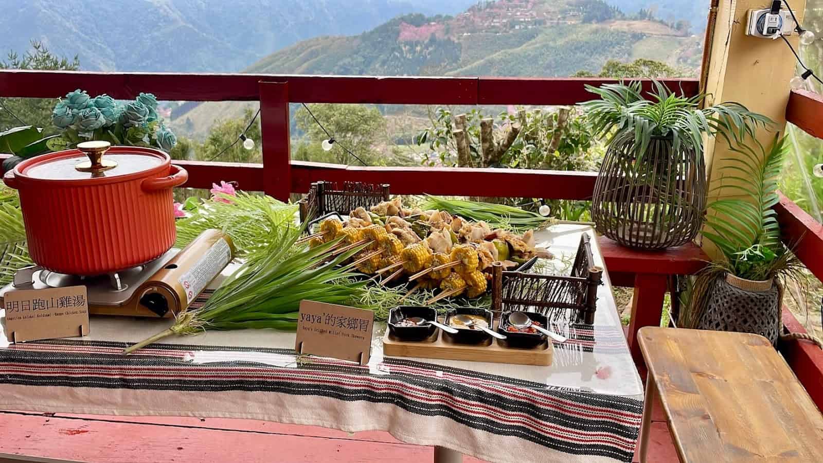 雲海上的部落餐桌，用山豬肉作的烤肉串與跑山雞湯，對面是白蘭部落